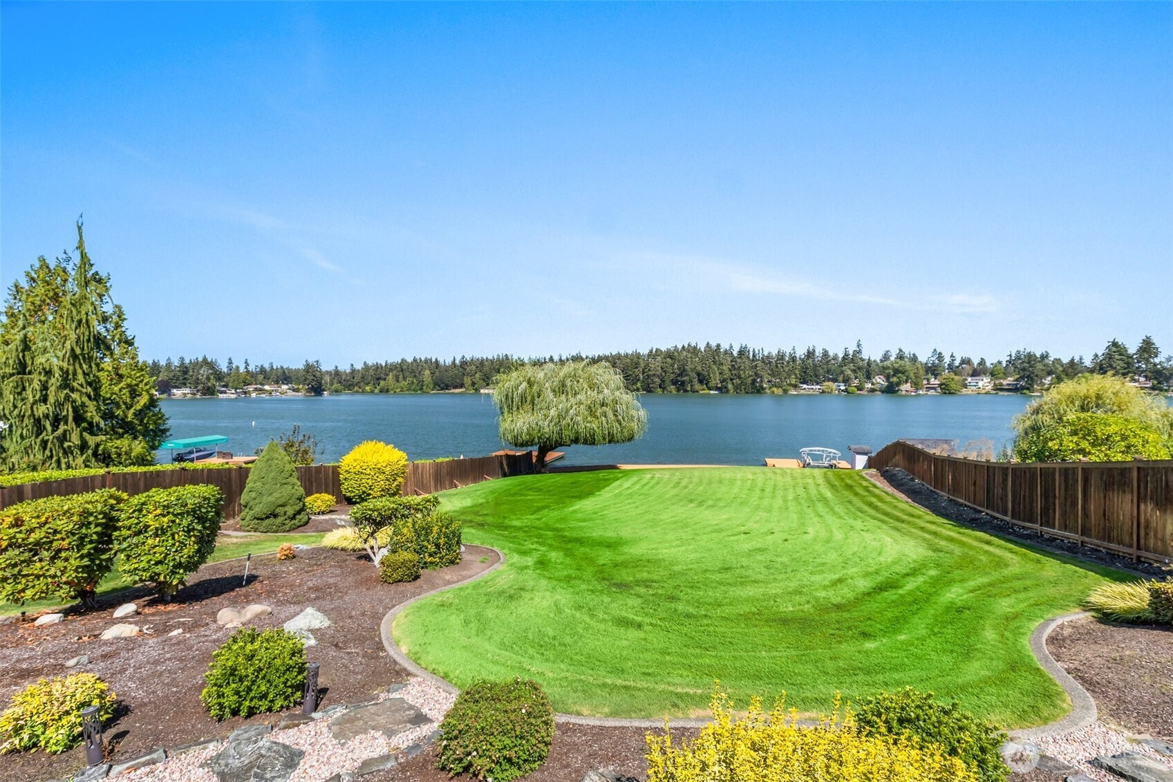 1207 Creso Road South Spanaway, WA 98387 - Photo 39 of 40 a view of a lake with couches and wooden fence