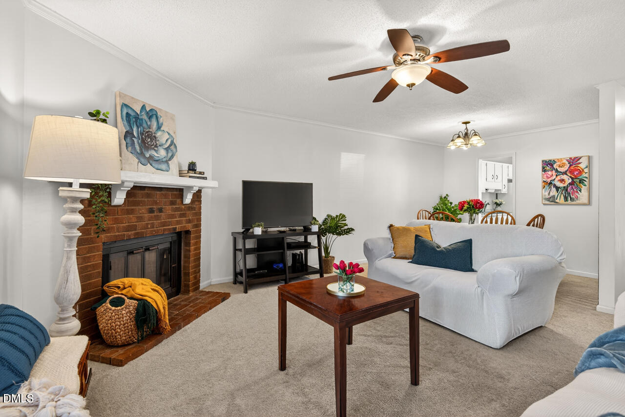 704 Benchmark Drive Raleigh, NC 27615 - Photo 3 of 39 a living room with furniture a fireplace and a flat screen tv