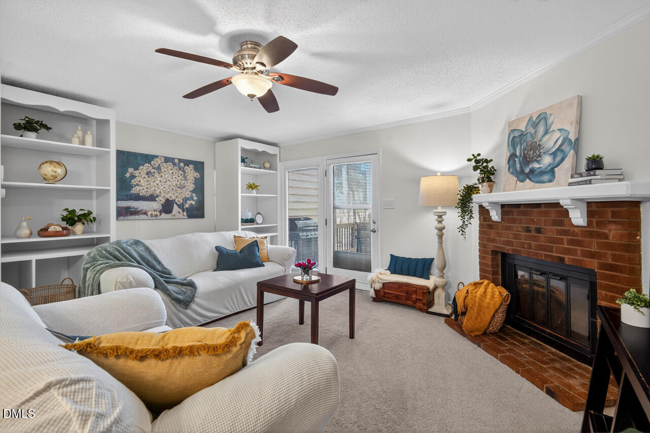 704 Benchmark Drive Raleigh, NC 27615 - Photo 4 of 39 a living room with furniture a fireplace and a chandelier