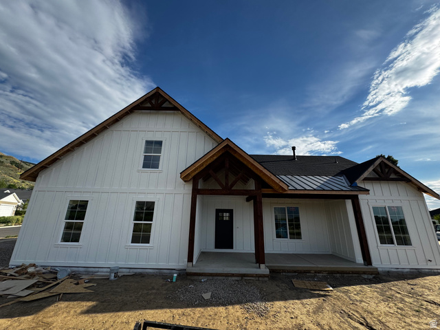 389 West 2100 South Perry, UT 84302 - Photo 1 of 21 Board and batten siding, dark framed windows, covered entry porch, exposed timber porch supports, and a dark shingle roof