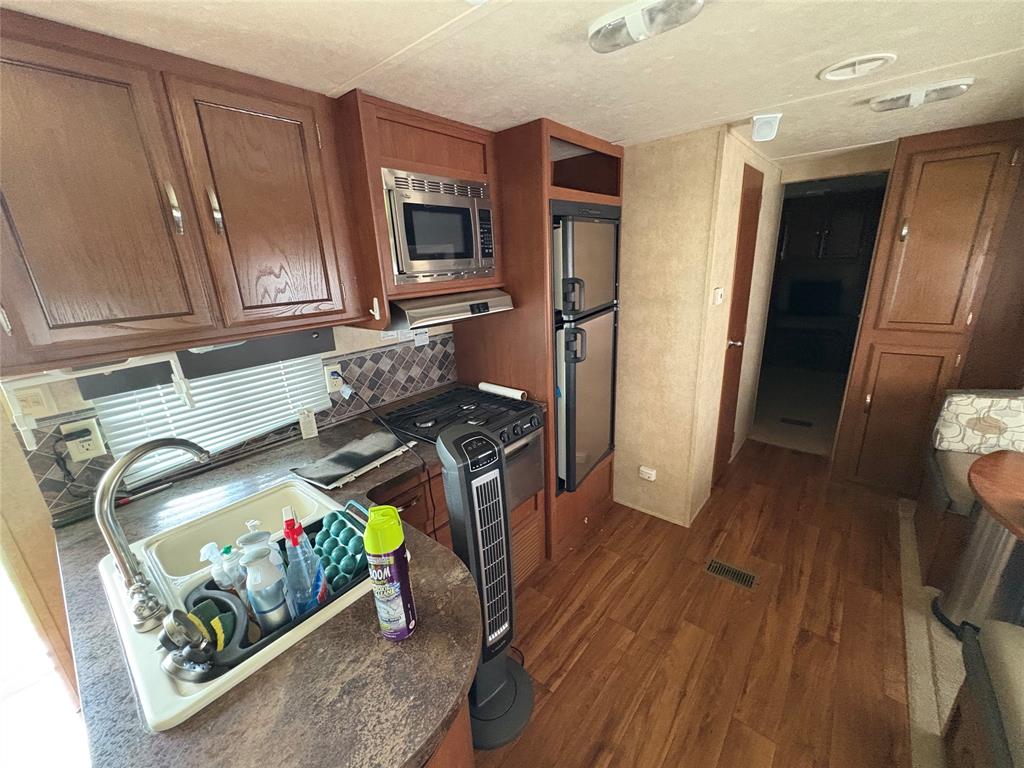 217 Wichita Quitman, TX 75783 - Photo 7 of 17 a kitchen with stainless steel appliances granite countertop a refrigerator and a microwave