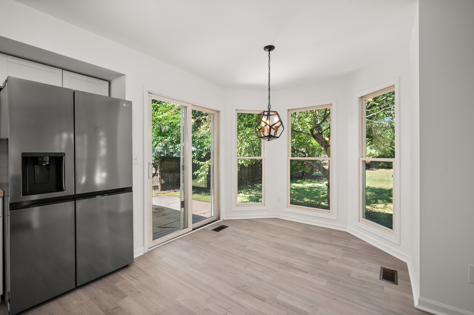 649 Fox Hollow Court DeKalb, IL 60115 - Photo 15 of 38 a view of an empty room with wooden floor fridge and windows