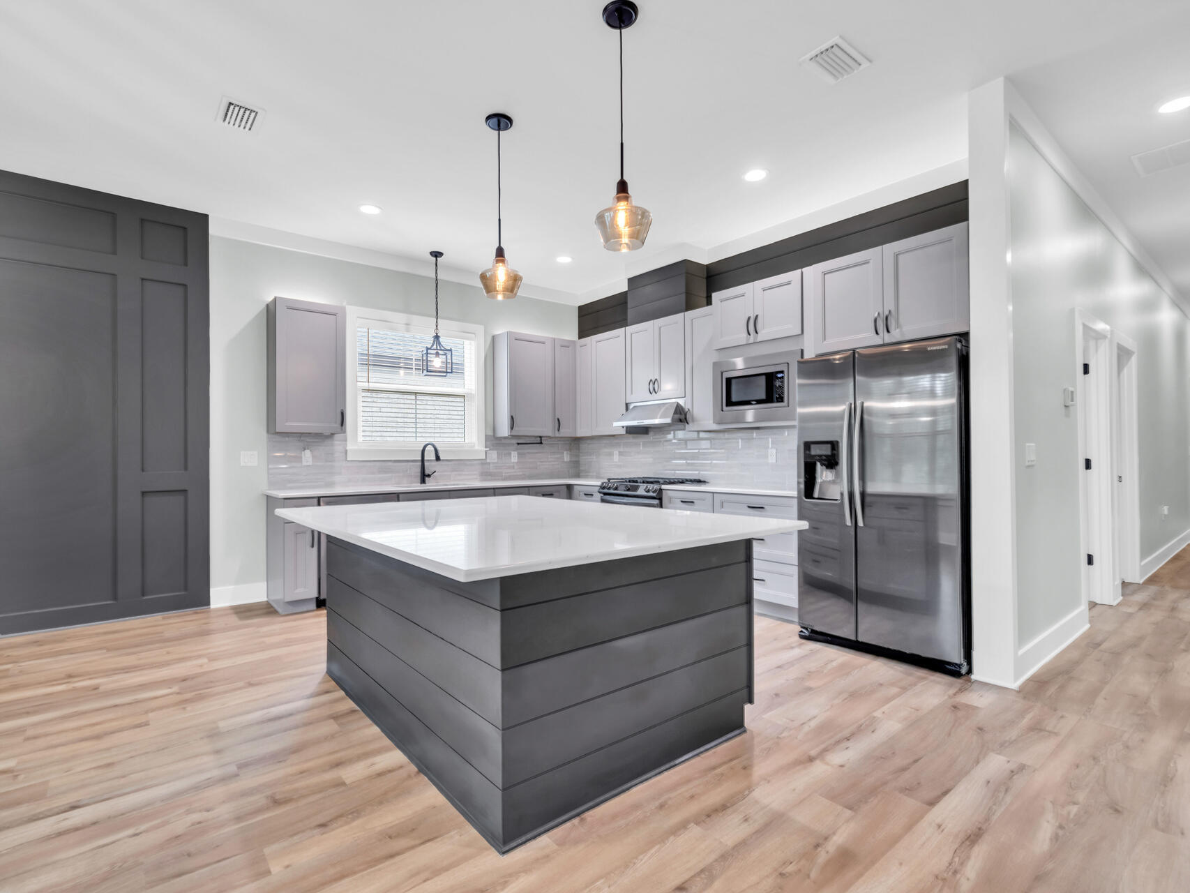 1160 Deer Moss Loop Niceville, FL 32578 - Photo 13 of 60 a kitchen with stainless steel appliances granite countertop a sink a stove a refrigerator and island with wooden floor