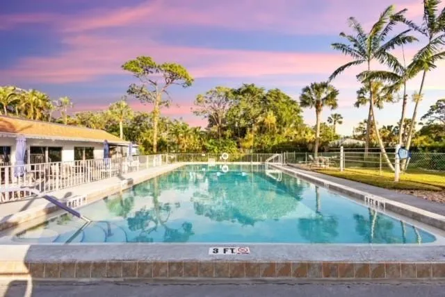 a view of a swimming pool with a lawn chairs under an umbrella