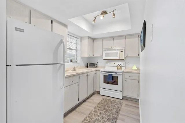a kitchen with a white cabinets and white appliances