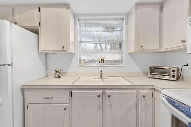 a kitchen with stainless steel appliances white cabinets a sink and a window
