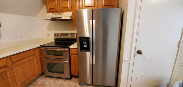 a kitchen with stainless steel appliances a refrigerator and a stove top oven