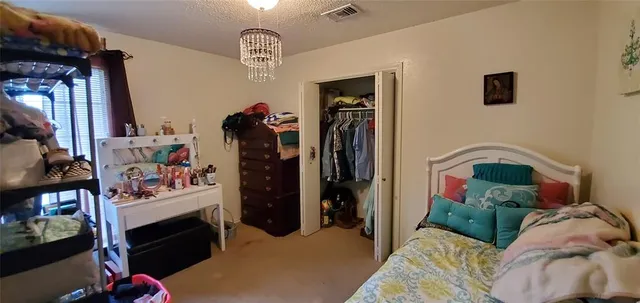 a bedroom with a bed a window and dresser