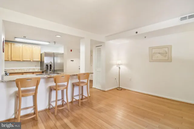 a view of a kitchen with kitchen island granite countertop wooden floor and a sink