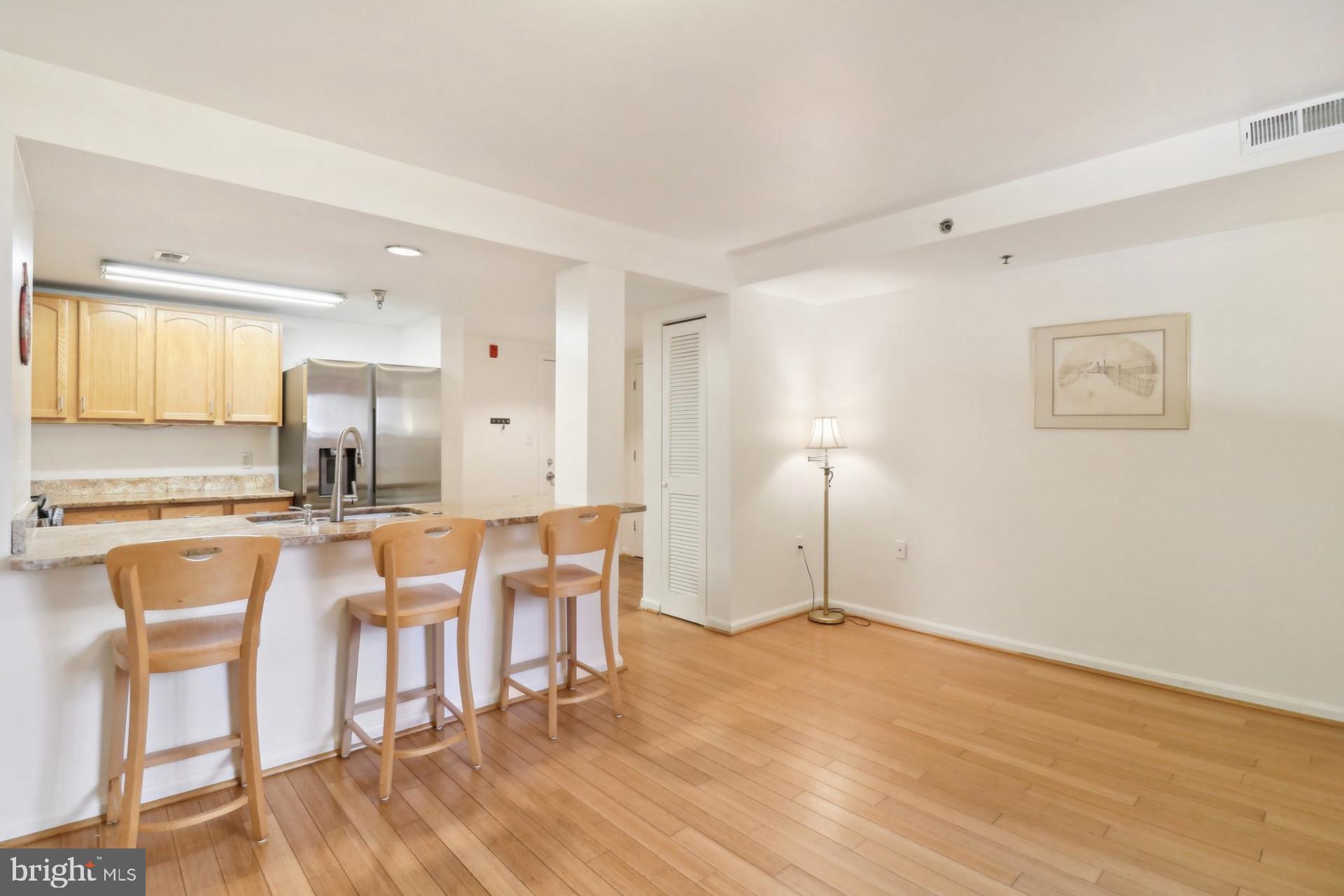 7981 Eastern Avenue Northwest, Unit 211 Silver Spring, MD 20910 - Photo 11 of 45 a view of a kitchen with kitchen island granite countertop wooden floor and a sink