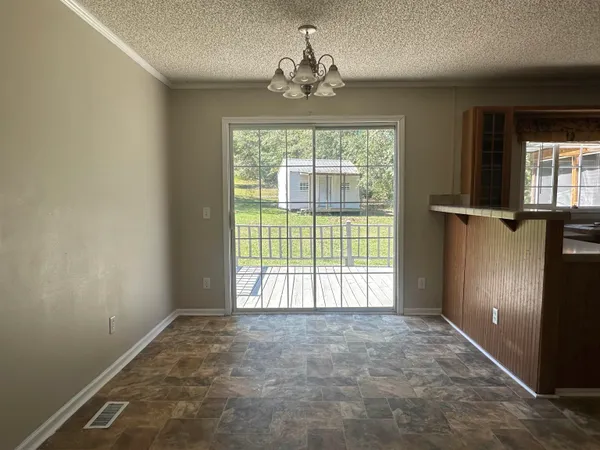 an empty room with a windows and chandelier
