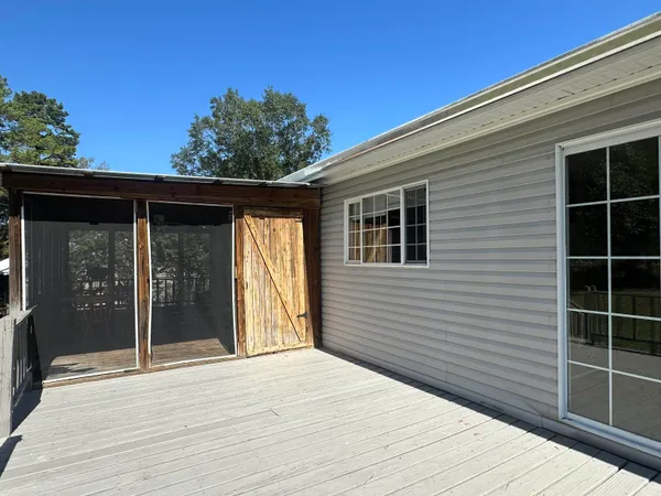 a backyard of a house with wooden floor and potted plants