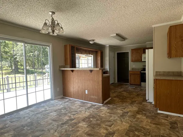a view of a big room with windows and chandelier
