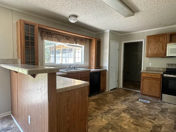 a kitchen with granite countertop a refrigerator and a sink