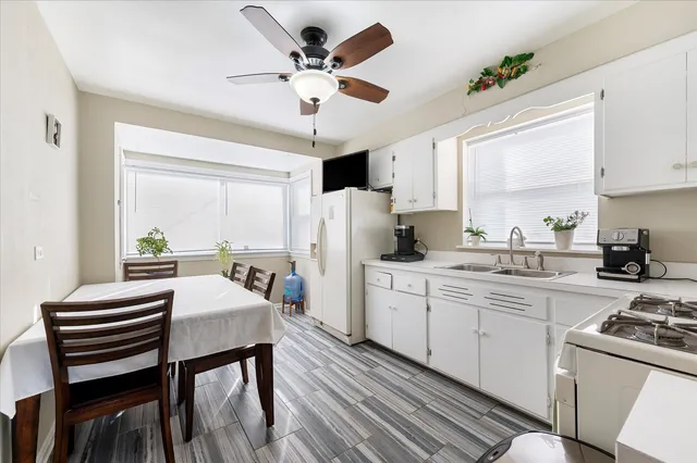 a kitchen with a refrigerator a sink dishwasher a oven with a dining table and chairs