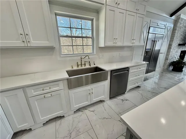 a bedroom with a bed a dresser and wooden floor
