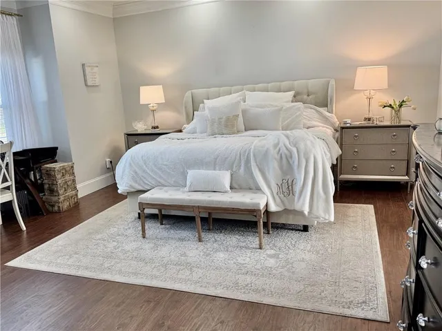 a bedroom with bed and a flat tv screen on dresser