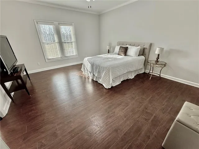 a bedroom with a bed a dresser and potted plants