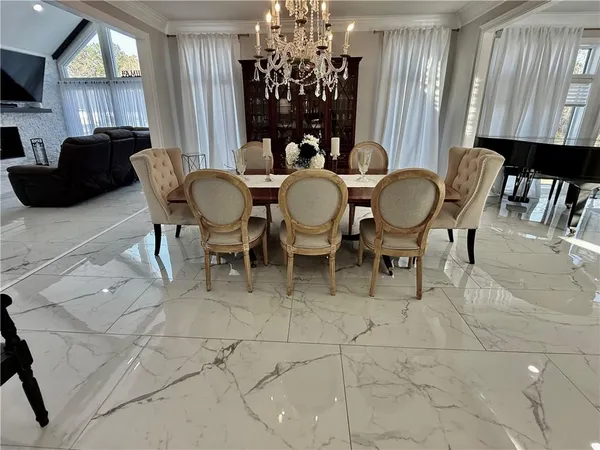 a kitchen with stainless steel appliances granite countertop a table chairs sink and white cabinets