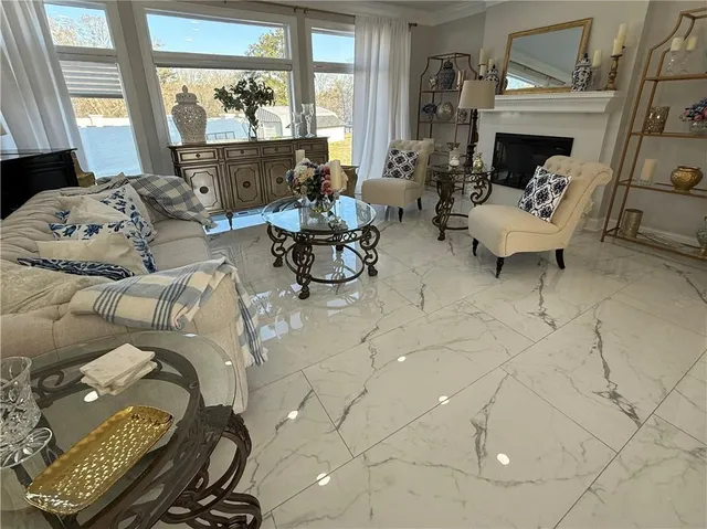 a kitchen with stainless steel appliances granite countertop a table chairs sink and white cabinets