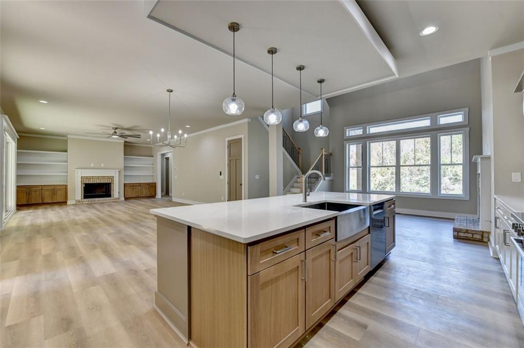 2881 Traditions Way Jefferson, GA 30549 - Photo 13 of 59 a large kitchen with kitchen island a stove a sink a center island and wooden floor