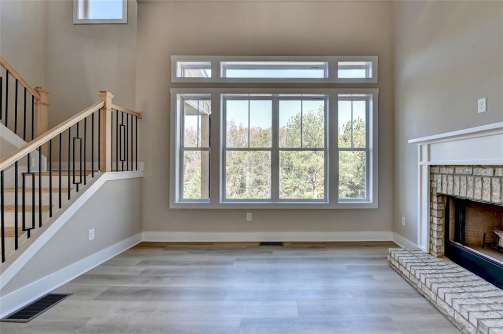 2881 Traditions Way Jefferson, GA 30549 - Photo 14 of 59 a view of an empty room with wooden floor a fireplace and a window