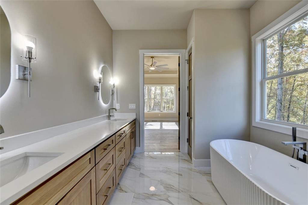 2881 Traditions Way Jefferson, GA 30549 - Photo 21 of 59 a bathroom with a tub sink and mirror