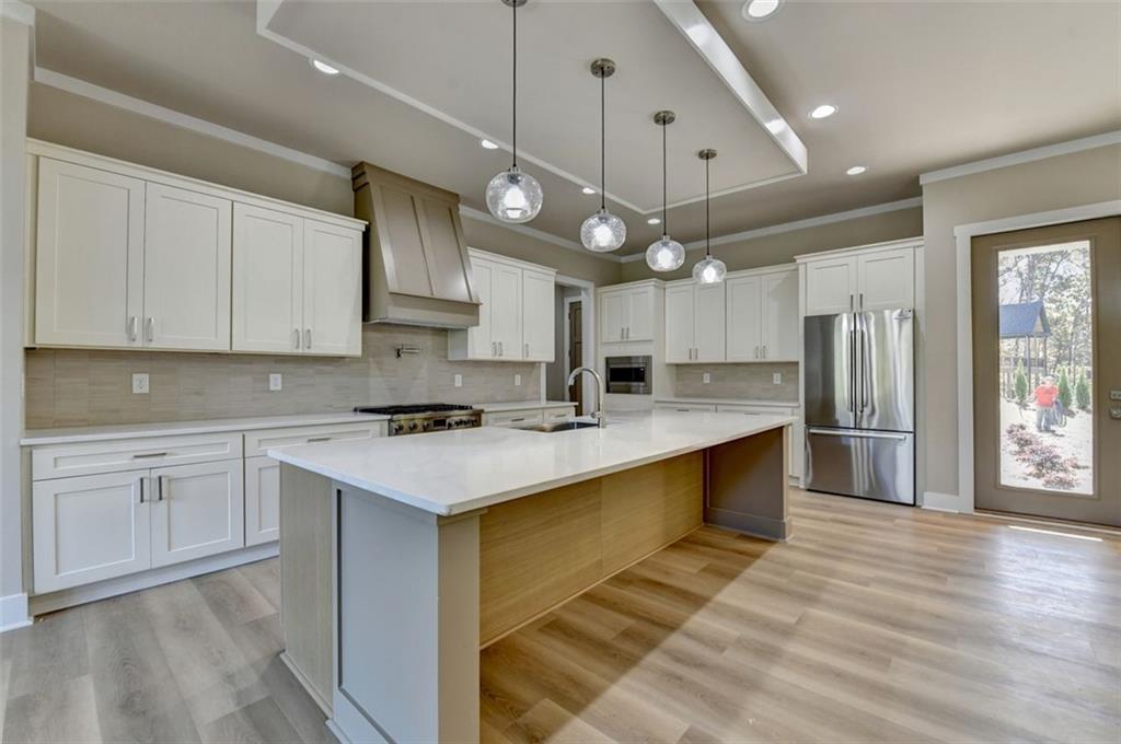 2881 Traditions Way Jefferson, GA 30549 - Photo 10 of 59 a kitchen with stainless steel appliances granite countertop a sink a stove and a refrigerator