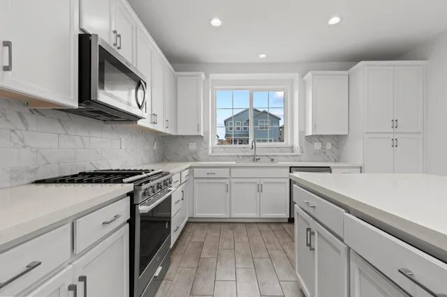 a kitchen with a sink stove oven and cabinets
