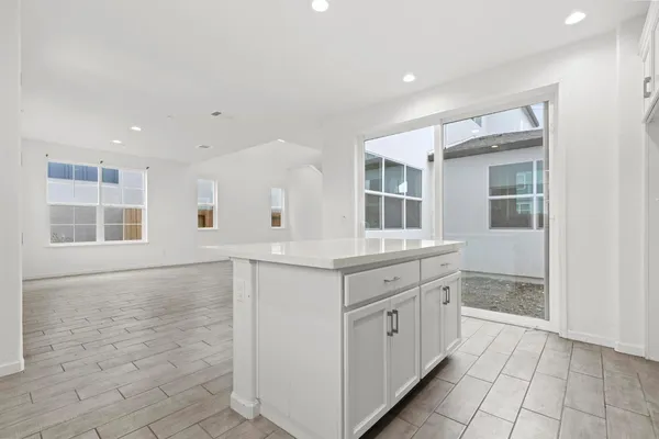 a kitchen with granite countertop white cabinets and white appliances