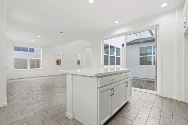 a kitchen with granite countertop white cabinets and white appliances