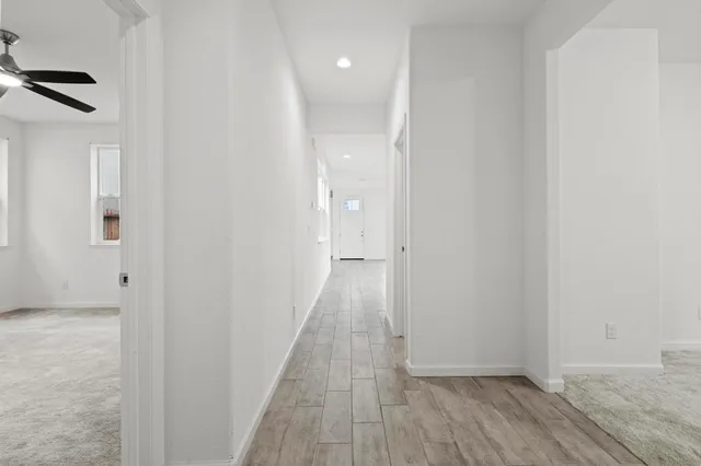 a view of a hallway with wooden floor