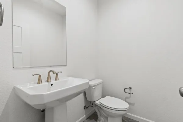 a bathroom with a sink a toilet and mirror