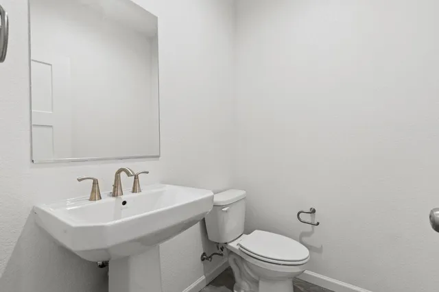a bathroom with a sink a toilet and mirror