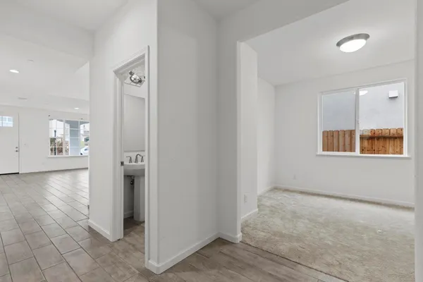 a view of a hallway with a room and wooden floor