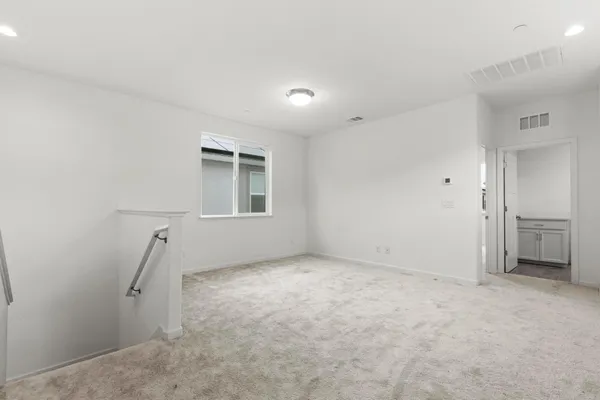 an empty room with a fireplace and windows