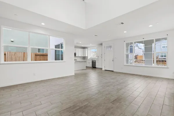 a view of empty room with wooden floor and windows