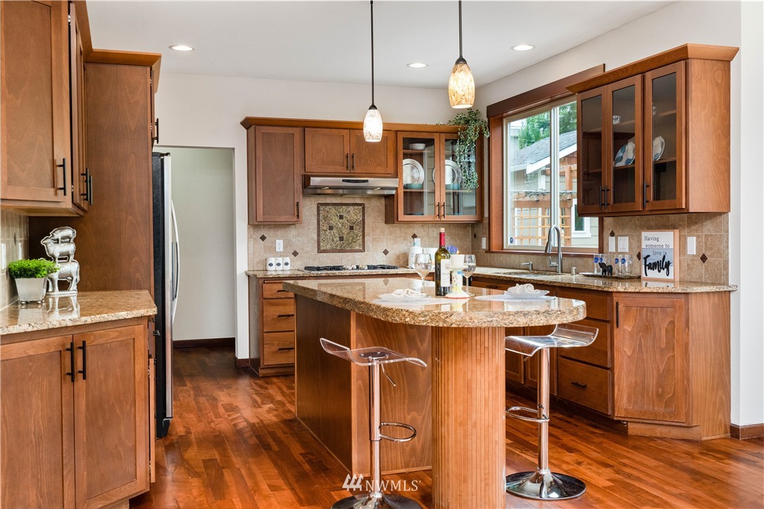 1317 North 40th Street Renton, WA 98056 - Photo 13 of 40 a kitchen with kitchen island granite countertop a sink stove and refrigerator