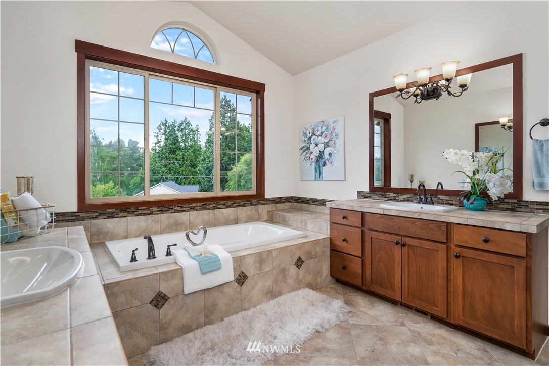 1317 North 40th Street Renton, WA 98056 - Photo 20 of 40 a spacious bathroom with a double vanity sink a large mirror and a bathtub next to a window