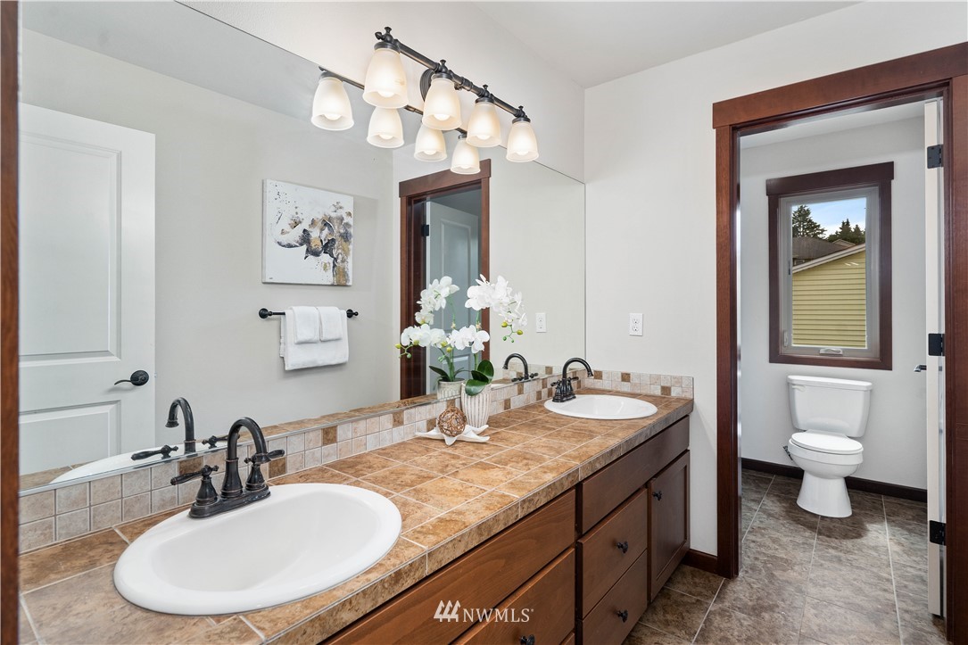 1317 North 40th Street Renton, WA 98056 - Photo 28 of 40 a bathroom with a granite countertop sink a toilet and a mirror