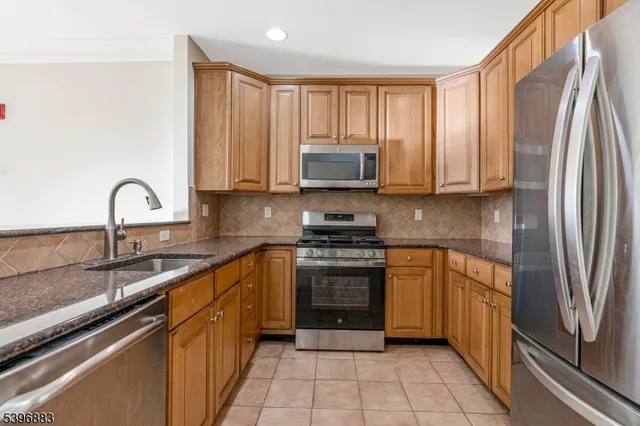 a kitchen with stainless steel appliances granite countertop a stove top oven a sink and dishwasher