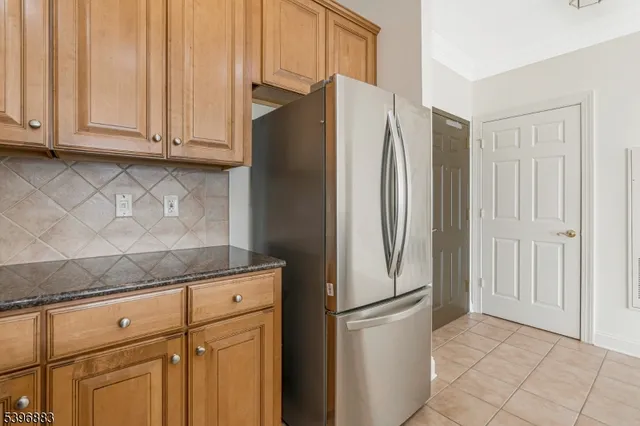 a metallic refrigerator freezer sitting in a kitchen