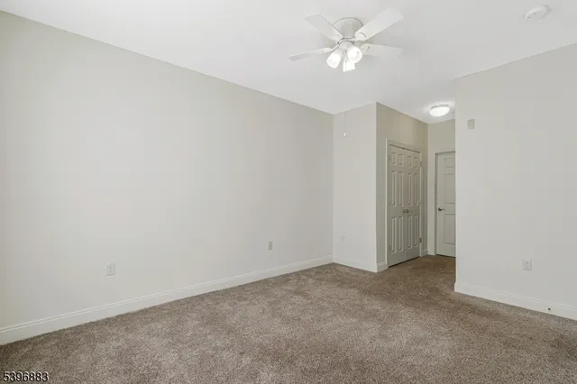 an empty room with a ceiling fan and a window