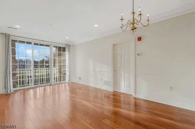 a view of a livingroom with wooden floor and a large window