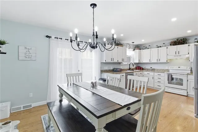 a kitchen with kitchen island a stove a table and chairs in it