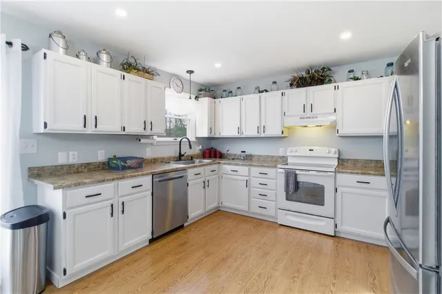 a kitchen with granite countertop white cabinets and white appliances