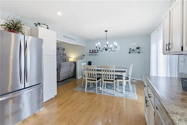 a dining room with furniture a chandelier and wooden floor