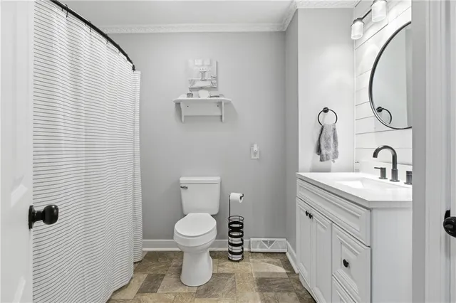 a bathroom with a toilet sink vanity and mirror