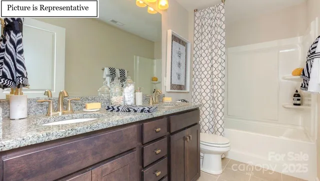 a bathroom with a granite countertop sink a toilet a mirror and shower