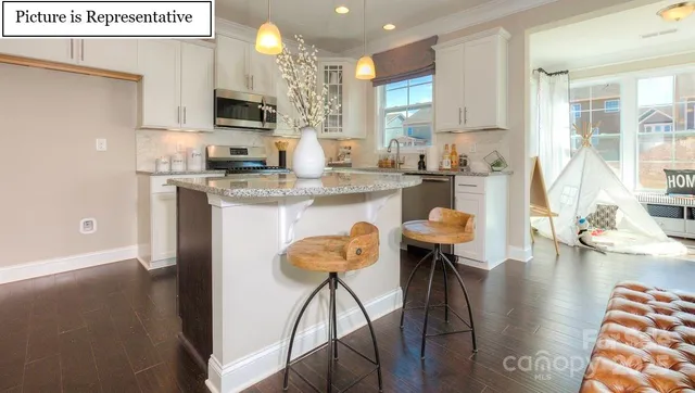 a kitchen with stainless steel appliances granite countertop a stove top oven a sink a counter space and cabinets